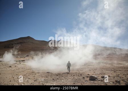 San Pablo, Bolivie. 21 mars 2024. Un homme marche dans El sol de Mañana une zone d'activité géothermique dans la Reserva nacional de fauna andina Eduardo Abaroa (réserve nationale de faune andine Eduardo Avaroa) à sur Lípez, Altiplano à une altitude de 4 900 mètres. Il contient des fumerolles, des geysers et des cratères. (Photo par Apolline Guillerot-Malick/SOPA images/Sipa USA) crédit : Sipa USA/Alamy Live News Banque D'Images