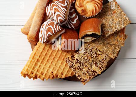 Variété de produits de boulangerie exposés sur un plateau en bois lors d'une réunion confortable de l'après-midi Banque D'Images