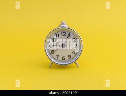 Réveil vintage sur fond jaune avec espace de copie. Banque D'Images