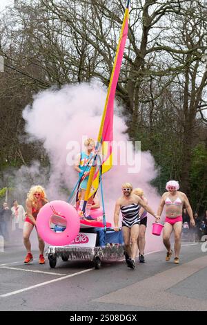 Windlesham, Surrey. Jeudi 26 décembre 2024. Les concurrents habillés en Barbies participent à la course annuelle de Windlesham Pram Day. L'événement caritatif qui a commencé en 1967 voit les coureurs compléter un parcours de 3,5 miles à travers le village de Windlesham dans le Surrey. Crédit : Katie Collins/Alamy Live News Banque D'Images