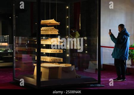 (241226) -- PÉKIN, Dec. 26, 2024 (Xinhua) -- Un homme prend des photos d'une maquette de la tour de tir à l'arc Zhengyangmen à l'intérieur de la tour de tir à l'arc Zhengyangmen à Pékin, capitale de la Chine, Dec. 26, 2024. Datant de la dynastie Ming (1368-1644), la tour de tir à l'arc Zhengyangmen, située le long de l'axe central de Pékin, a rouvert au public jeudi. Située à l'extrémité sud de la place Tian'anmen, la porte Zhengyangmen comprend deux structures : la tour de la porte au nord et la tour du tir à l'arc au sud. La porte met en évidence les pratiques traditionnelles de gestion urbaine de la Chine ancienne. Pendant la Banque D'Images