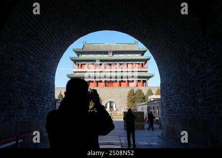 (241226) -- PÉKIN, Dec. 26, 2024 (Xinhua) -- Un homme prend des photos de la porte Zhengyangmen sous la Tour de tir à l'arc Zhengyangmen à Pékin, capitale de la Chine, Dec. 26, 2024. Datant de la dynastie Ming (1368-1644), la tour de tir à l'arc Zhengyangmen, située le long de l'axe central de Pékin, a rouvert au public jeudi. Située à l'extrémité sud de la place Tian'anmen, la porte Zhengyangmen comprend deux structures : la tour de la porte au nord et la tour du tir à l'arc au sud. La porte met en évidence les pratiques traditionnelles de gestion urbaine de la Chine ancienne. Pendant les Ming et Qing Dy Banque D'Images