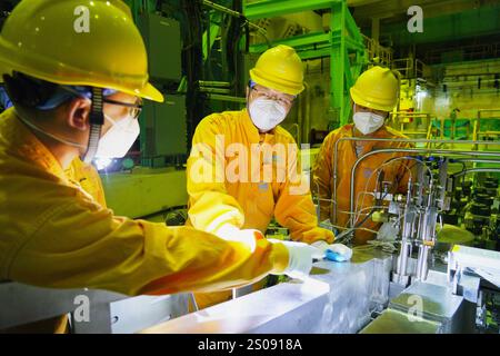 (241226) -- PÉKIN, 26 décembre 2024 (Xinhua) -- cette photo prise le 26 décembre 2024 montre des ouvriers ajustant et testant le premier réacteur commercial de Chine pour la production en ligne d'isotopes par irradiation à la base nucléaire de Qinshan exploitée par la China National Nuclear Corporation (CNNC). POUR ALLER AVEC « le premier réacteur commercial de Chine pour la production d'isotopes commence à fonctionner » (CNNC/Handout via Xinhua) Banque D'Images