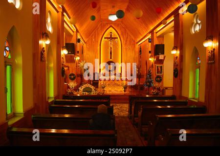 Un adorateur chrétien prie seul à l’intérieur de l’Église catholique de la Sainte famille pendant les célébrations de Noël à Srinagar, Jammu-et-Cachemire, le 25 décembre 2024. Des recherches menées au Royaume-Uni ont révélé que le nombre de jeunes qui passent le seul jour de Noël a été multiplié par neuf, comparant les tendances festives de 2024 à 1969. L’étude menée par le Policy Institute du King’s College de Londres a montré que le nombre total de personnes qui passent Noël à lui seul a plus que doublé, passant de 5 % à 11 % au cours des 55 dernières années. Parmi les 21 à 34 ans, un sur 11 célébrera la fête A. Banque D'Images