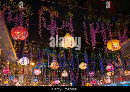 Des lanternes colorées et des fleurs vibrantes décorent l'espace sous un beau ciel nocturne Banque D'Images