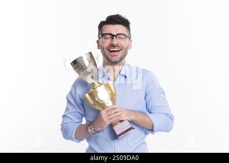 Heureux homme d'affaires réussi tenir la récompense d'affaires de coupe de champion isolé sur blanc. Banque D'Images