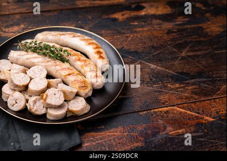 Saucisses grillées avec de la viande de forçage mincemat et des herbes dans l'assiette. fond en bois. vue de dessus. Banque D'Images