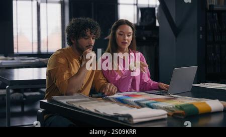 Homme arabe femme caucasienne collègues femme designer de mode femme styliste tailleur masculin discuter des échantillons de tissu dans atelier multiracial fille gars acheteurs Banque D'Images