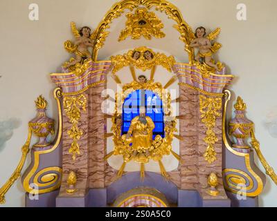 L'image présente un autel détaillé avec une figure centrale dorée, entourée de figures chérubiennes et de détails dorés, sur un bleu éclatant St Banque D'Images