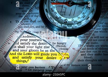 Une boussole avec une loupe placée sur une Bible anglaise, en se concentrant sur le verset surligné : «et le Seigneur vous guidera continuellement, et satis Banque D'Images