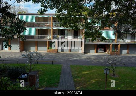 Un immeuble typique de banlieue australienne à Glenbrook avec des auvents de balcon rayés, une façade en brique, des garages et un jardin paysager avant Wit Banque D'Images