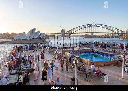 Fête en bateau sur le pont du Cunard Queen Elizabeth alors que le bateau de croisière quitte le port de Sydney avec l'Opéra et le pont du port derrière, Australie Banque D'Images