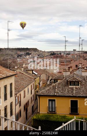 Une montgolfière survole les toits de la ville de Ségovie, en Espagne. Banque D'Images