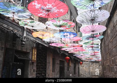 QIANDONGNAN, CHINE - 26 DÉCEMBRE 2024 - des parapluies en papier à huile suspendus au-dessus de Fuxing Lane pendent au-dessus de Fuxing Lane dans la ville antique de Zhenyuan, Qiandongnan Mi Banque D'Images