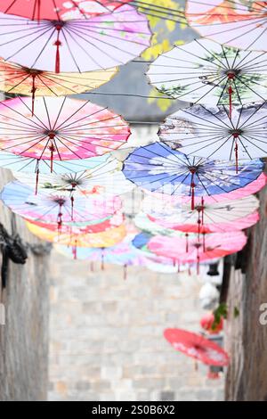 QIANDONGNAN, CHINE - 26 DÉCEMBRE 2024 - des parapluies en papier à huile suspendus au-dessus de Fuxing Lane pendent au-dessus de Fuxing Lane dans la ville antique de Zhenyuan, Qiandongnan Mi Banque D'Images
