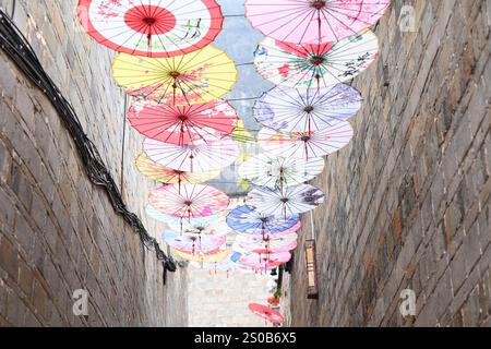 QIANDONGNAN, CHINE - 26 DÉCEMBRE 2024 - des parapluies en papier à huile suspendus au-dessus de Fuxing Lane pendent au-dessus de Fuxing Lane dans la ville antique de Zhenyuan, Qiandongnan Mi Banque D'Images