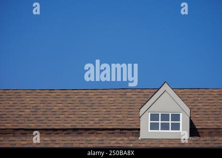 toit orange de la maison avec cadre de fenêtre blanc dans le ciel bleu foncé clair Banque D'Images
