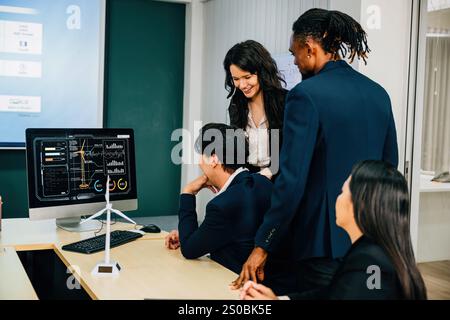 Un groupe diversifié de collègues se réunissant autour d'un ordinateur de bureau, discutant activement de stratégie et Banque D'Images