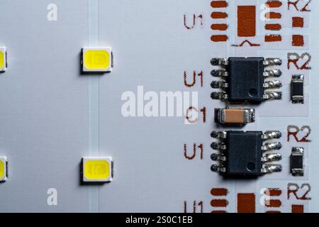 Panneau LED blanc avec lumière jaune et micropuce sur fond, vue de dessus, gros plan Banque D'Images