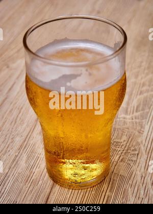 Verre de bière sur un fond en bois. Bière dans un verre. Banque D'Images