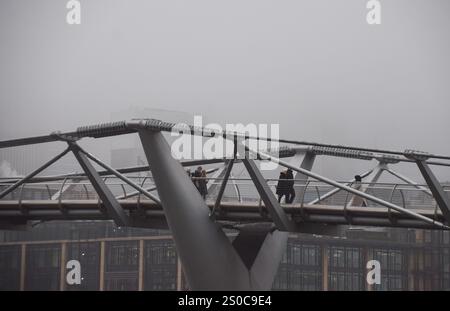 Londres, Royaume-Uni. 27 décembre 2024. Les gens marchent le long du Millennium Bridge devant un horizon complètement obscurci de la City of London, le quartier financier, tandis que le brouillard descend sur la capitale. Crédit : Vuk Valcic/Alamy Live News Banque D'Images