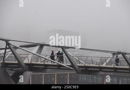 Londres, Royaume-Uni. 27 décembre 2024. Les gens marchent le long du Millennium Bridge devant un horizon complètement obscurci de la City of London, le quartier financier, tandis que le brouillard descend sur la capitale. Crédit : Vuk Valcic/Alamy Live News Banque D'Images