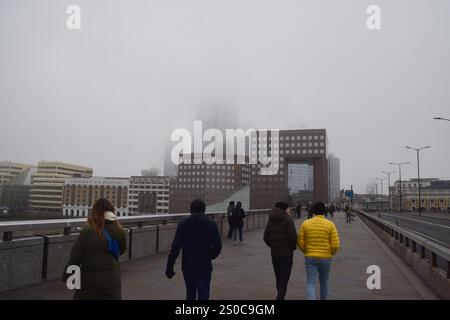 Londres, Royaume-Uni. 27 décembre 2024. Les gens marchent le long du London Bridge en passant devant un bâtiment Shard obsédé tandis que le brouillard descend sur la capitale. Crédit : Vuk Valcic/Alamy Live News Banque D'Images