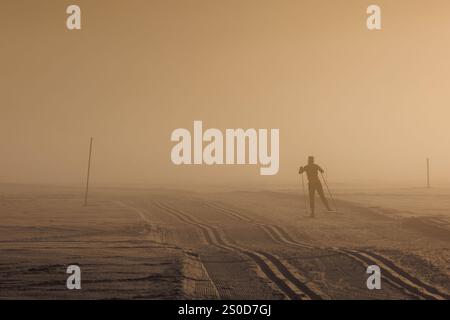 Oberstdorf, Allemagne. 27 décembre 2024. Un skieur de fond glisse sur un sentier dans la brume du soleil du soir. Crédit : Daniel Karmann/dpa/Alamy Live News Banque D'Images