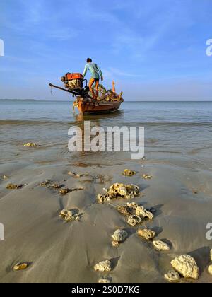 Phuket, Thaïlande, le 26 mars 2021 : un pêcheur dirige son bateau à longue queue vers la mer pour une prise. Banque D'Images