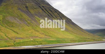 Isafjordur, Islande - 25 août 2024 : vue panoramique de la piste de l'aéroport sous une grande montagne dans la ville reculée d'Isafjordur dans le Nborth of Ice Banque D'Images