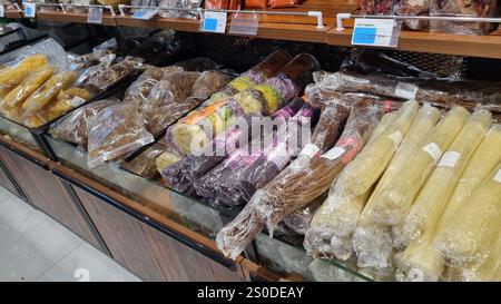 Présentation de divers aliments séchés dans un emballage transparent, y compris des nouilles, des légumes conservés et des herbes, disposés soigneusement dans une épicerie. Banque D'Images