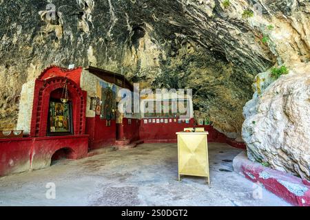 Intérieur du temple de la grotte de Panagia Lagadiotissa, décoré d'icônes religieuses, de fresques et de formations rocheuses naturelles se mélangeant à un lieu de culte. Banque D'Images