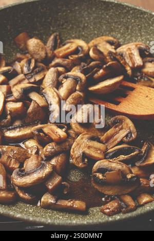 Champignons frits dans une poêle, avec une fourchette en bois, fait maison, pas de gens Banque D'Images