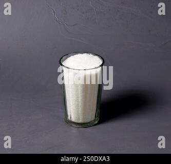 Tasse en verre transparent remplie de sucre. Banque D'Images