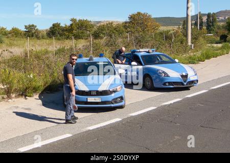 Civitavecchia, Italie - 27 décembre 2024 : voitures de police italiennes, une Fiat et une Alfa Romeo, garées sur la route. Les officiers sont présents. Concept : police pré Banque D'Images