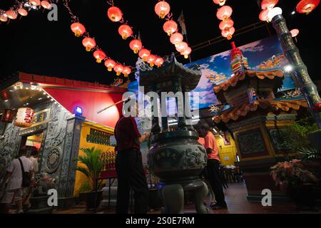 Penang, Malaisie - 29 janvier 2023 : homme offrant des bâtons d'encens au temple Chew Jetty pour le nouvel an chinois Banque D'Images