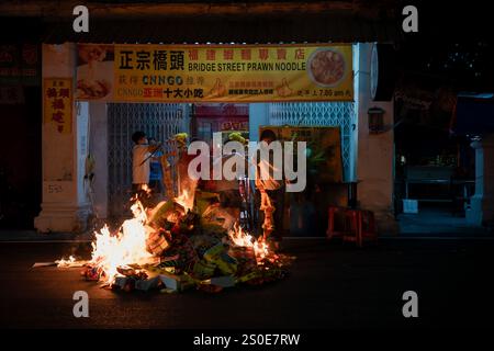 Georgetown, Penang, Malaisie - 29 janvier 2023 : les habitants brûlent des offres dans la rue pour le nouvel an chinois Banque D'Images