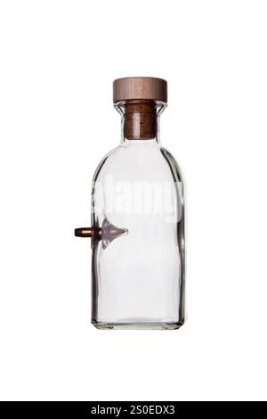 Une bouteille en verre transparent avec un liège en bois et un petit bec sur le côté, idéale pour stocker et verser des liquides, isolée sur fond blanc. Banque D'Images