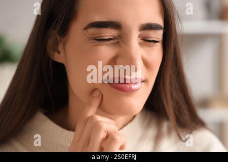 Jeune femme souffrant de maux de dents à la maison, gros plan Banque D'Images