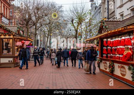 Une vue le long de Broad Street à Reading, Berkshire, Royaume-Uni en décembre 2024 avec des décorations de Noël suspendues au-dessus de la tête et des étals de marché de Noël Banque D'Images