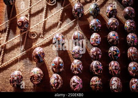 Un tas de perles colorées sont disposées en rangée. Les perles sont de différentes tailles et couleurs, et elles sont toutes alignées sur un tissu marron. L'arrangem Banque D'Images