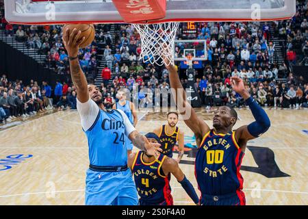 Inglewood, États-Unis. 27 décembre 2024. Norman Powell (l) des Los Angeles Clippers monte dans le panier lors du match de saison régulière NBA 2024-2025 entre les Golden State Warriors et les Los Angeles Clippers à Inglewood, États-Unis, 27 décembre 2024. Crédit : Zhao Hanrong/Xinhua/Alamy Live News Banque D'Images