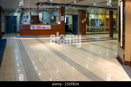 PHOTOS DU DOSSIER : en mer, St Nazaire-Gijon. 28 décembre 2024 : Hall d'entrée, réception et boutiques à bord du ferry NORMAN ATLANTIC. Regardez en arrière ce navire tristement célèbre qui a brûlé il y a exactement 10 ans, dans la nuit du 27 au 28 décembre 2014 au large des côtes albanaises, causant la mort d'au moins 30 personnes (19 toujours portées disparues) dont 2 sauveteurs et la blessure de 64 passagers / équipage. Propriété de la ligne de ferries italiennes Visemar, affrétée par la grecque Anek Lines, le navire moderne, construit 5 ans plus tôt, a pris feu dans le garage en raison des camions laissés en marche pendant la navigation, ce qui est interdit. Le navire... Crédit : KEVIN IZORCE/Alamy Live News Banque D'Images