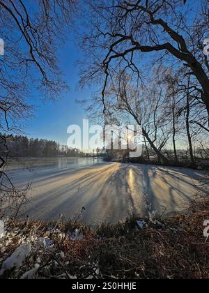 28.12.2024, hiver dans le Bayern. Bad Wörishofen im Unterallgäu. Abendstimmung am Waldsee im Süden der Stadt, die Wasserfläche ist zugefroren, die Kälte ist spürbar in der untergehenden Abendsonne. 28.12.2024, Bad Wörishofen 28.12.2024, Bad Wörishofen *** 28 12 2024, hiver en Bavière Bad Wörishofen à Unterallgäu ambiance nocturne au lac forestier au sud de la ville, la surface de l'eau est gelée, le froid est perceptible dans le coucher du soleil du soir 28 12 2024, Bad Wörishofen 28 12 2024, Bad Wörishofen Banque D'Images