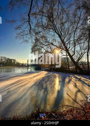 28.12.2024, hiver dans le Bayern. Bad Wörishofen im Unterallgäu. Abendstimmung am Waldsee im Süden der Stadt, die Wasserfläche ist zugefroren, die Kälte ist spürbar in der untergehenden Abendsonne. 28.12.2024, Bad Wörishofen 28.12.2024, Bad Wörishofen *** 28 12 2024, hiver en Bavière Bad Wörishofen à Unterallgäu ambiance nocturne au lac forestier au sud de la ville, la surface de l'eau est gelée, le froid est perceptible dans le coucher du soleil du soir 28 12 2024, Bad Wörishofen 28 12 2024, Bad Wörishofen Banque D'Images