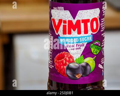 Bouteille de boisson gazeuse aromatisée aux fruits Vimto sans sucre ajouté sur une surface en bois. Banque D'Images