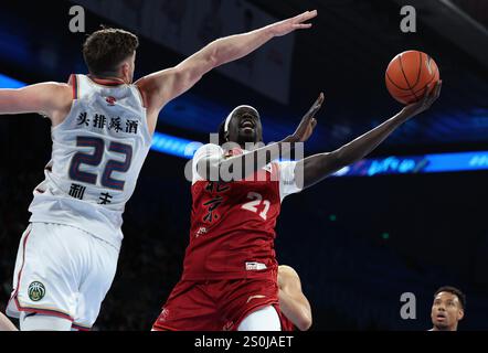 Pékin, Chine. 28 décembre 2024. Nuni Omot (avant R) des Ducks de Pékin part pour un match entre les Ducks de Pékin et les Monkey Kings de Nanjing lors de la saison 2024-2025 de la ligue de l'Association chinoise de basket-ball (CBA) à Pékin, Chine, Dec. 28, 2024. Crédit : Wang Kaiyan/Xinhua/Alamy Live News Banque D'Images