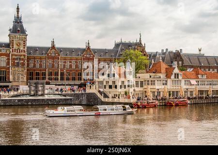 Tour en bateau dans l'Oosterdok avec la gare centrale d'Amsterdam en arrière-plan, Amsterdam, Hollande, pays-Bas. Banque D'Images