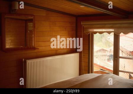 Intérieur en bois classique vintage avec radiateur de chauffage et lumière naturelle dans un village montagneux rural Banque D'Images