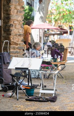 Un groupe d'artistes plus âgés peignent sur la place avec la fontaine de Pablo Picasso dans le centre historique de Cerét, France Banque D'Images